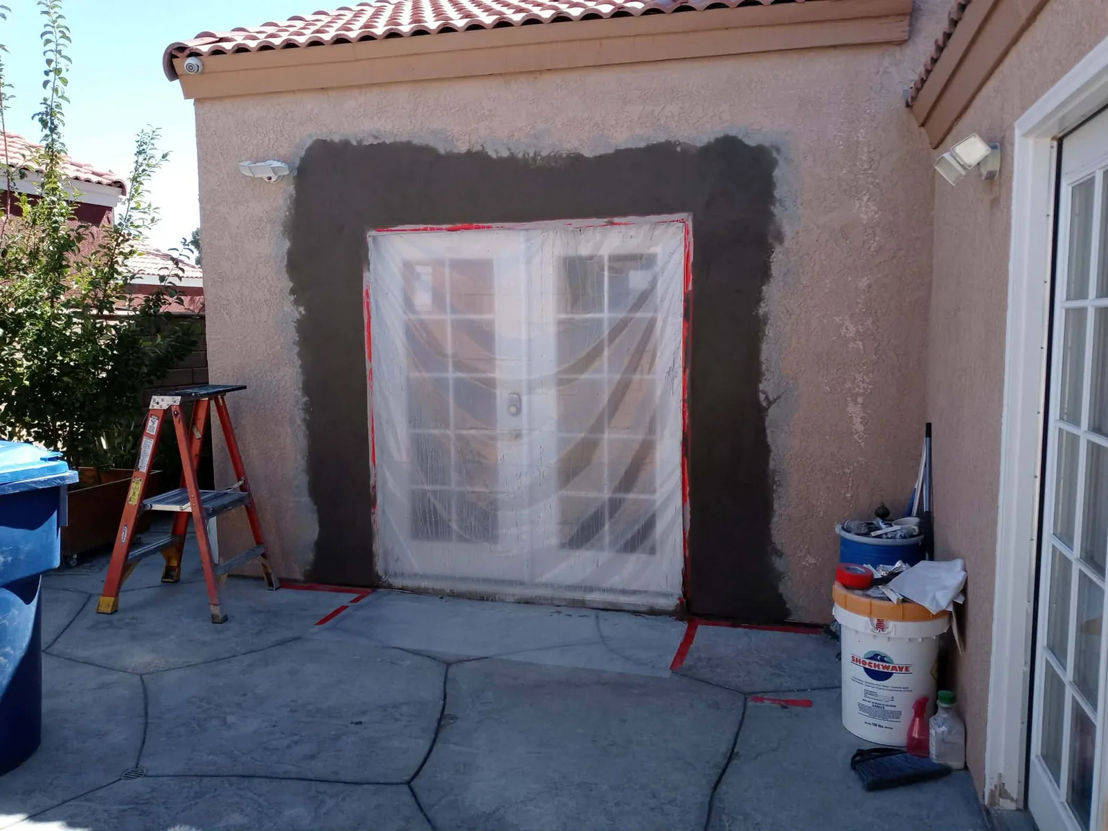 Exterior stucco repair preparation around a patio door